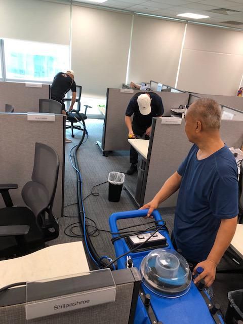 Three-man Yuki & White crew running a carpet extraction machine between workstations