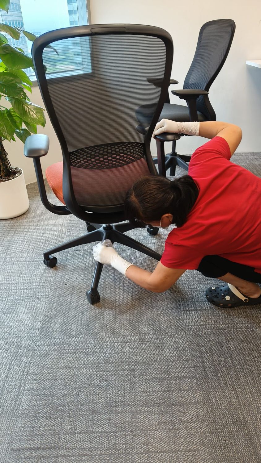 Cleaner detailing the base and castors of an office chair