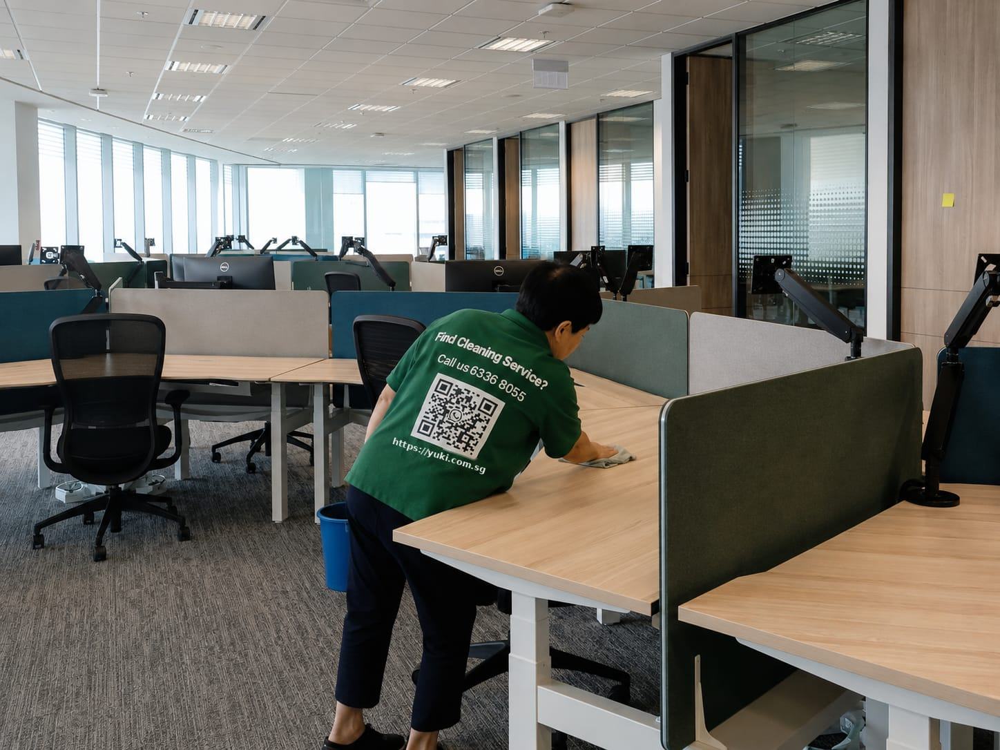 Yuki & White cleaner wiping down workstations in a Singapore office