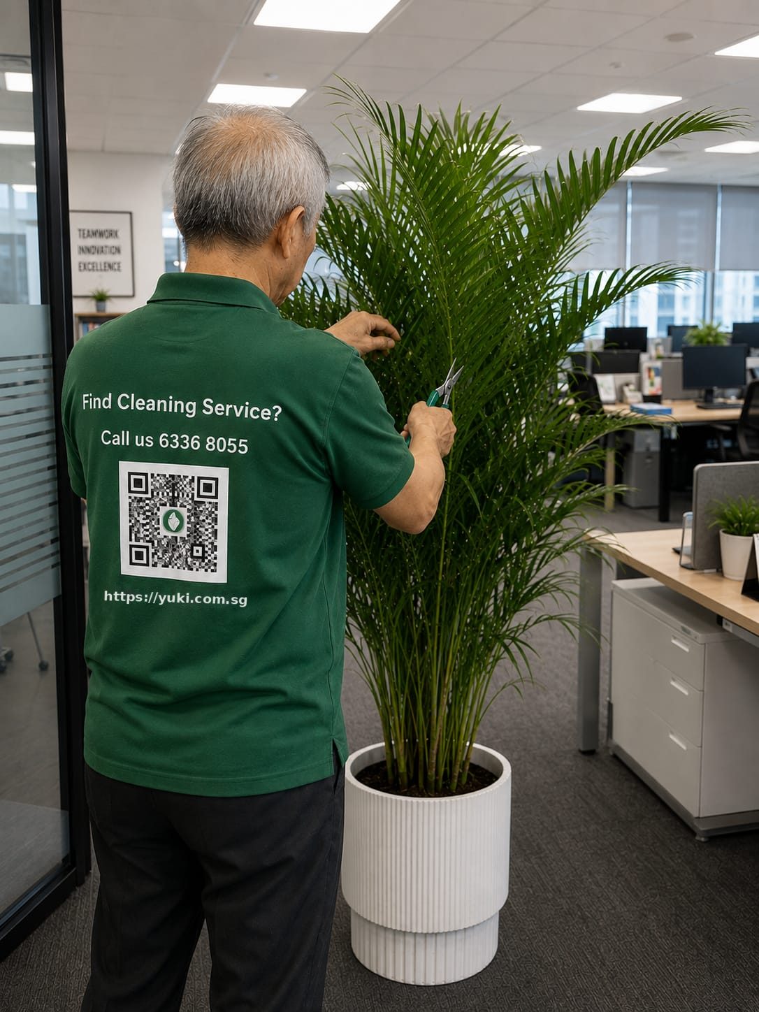 Yuki & White horticulturist pruning an areca palm inside a Singapore office
